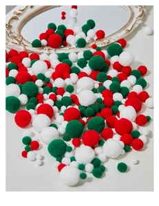 Detail of red, green, and white Christmas pom-poms for festive DIY craft projects