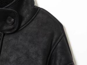 Detail shot of black faux suede jacket neckline buttons and high-quality shoulder stitching