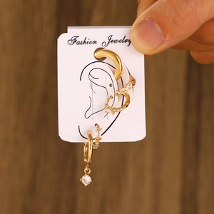 Macro shot of gold ear piercing set with clear zircons on a white display card