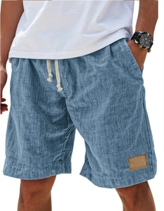 Detail of blue linen-textured shorts featuring a drawstring waist and decorative leather tag