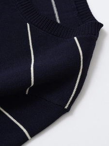 Detail of ribbed crew neck and fine knit fabric texture on navy striped sweater