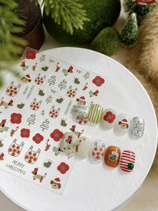 Christmas nail art stickers featuring dogs, socks and trees on a white pedestal