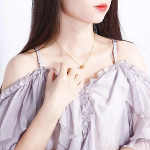 Elegant gold titanium steel necklace with diamond pattern cylinder pendant on female model