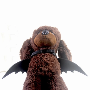 Halloween bat wings costume for small dogs and cats on a brown plush teddy pet