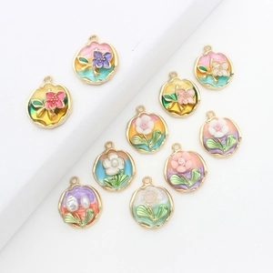 Macro detail of colorful floral enamel charms with gold trim and pearl accents
