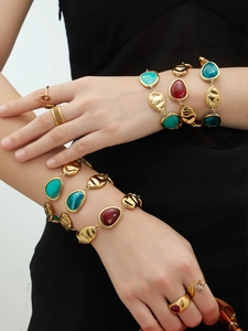 Detail of vintage 18K gold plated chain bracelets with colorful resin teardrop stones