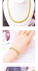 Close-up of golden flat Cuban chain necklace, bracelet and braided ring set
