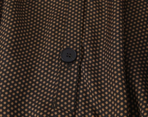 Détail macro du tissu à pois avec bouton noir et finitions de couture de précision