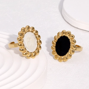 Macro detail of retro sunflower enamel rings in gold finish on minimalist white background