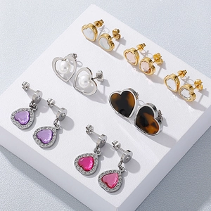 Elegant assortment of heart-shaped pearl and rhinestone earrings on a display stand
