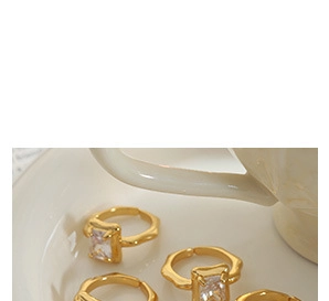 Detailed macro view of gold plated couple ring with emerald cut zircon and lava texture