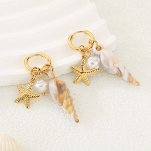 Detailaufnahme goldener Seestern- und Muschelohrringe mit einer weißen Perle verziert