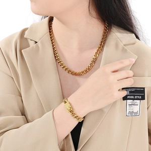 Polished gold Cuban link chain necklace and bracelet set for men and women on model