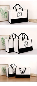 Detail of white canvas tote bag with black handles and floral letter C embroidery