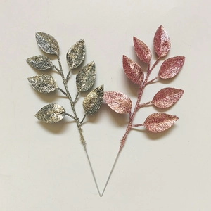 Macro view of artificial Christmas leaves with silver and rose gold glitter coating