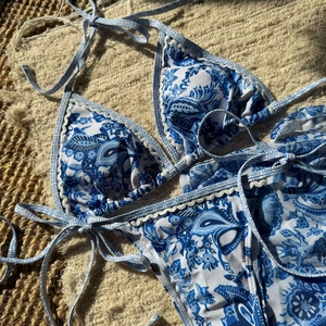 Bikini imprimé cachemire bleu et blanc avec bordure en dentelle crochetée sur tapis blanc