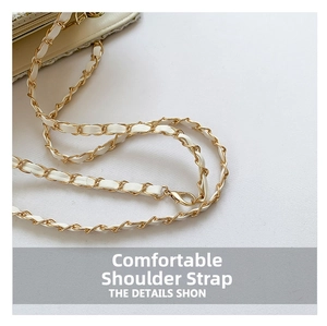 Detail of white leather interwoven with golden metal chain strap on plaid tote bag
