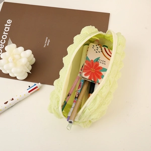 Detail of mint green seersucker pencil case showing its large storage capacity for pens
