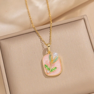 Golden necklace featuring a rectangular pink tulip pendant with pearl on jewelry box
