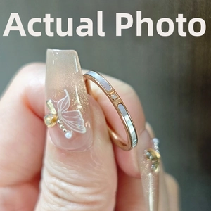 Macro shot of 18k rose gold plated titanium ring with white shell and small diamond detail