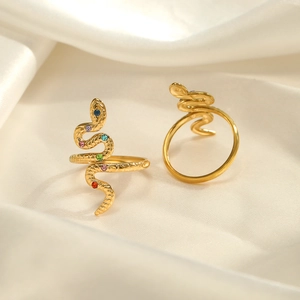 Golden snake-shaped rings with colorful zircon inlays on white satin fabric