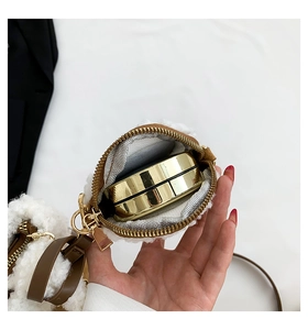 Close-up of plush lamb wool bucket bag showing interior space with a gold powder compact