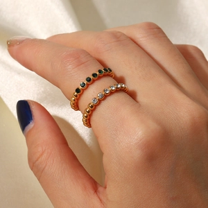 Detail of 18K gold plated bead rings with emerald green and white zircon on silk