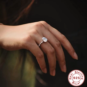 Macro shot of oval-cut diamond ring in 925 sterling silver worn on a finger