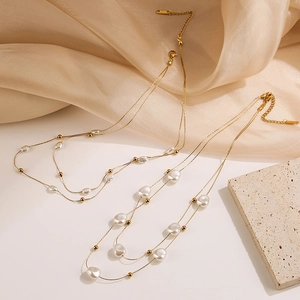 Baroque pearl layered necklace with gold beads on elegant silk background