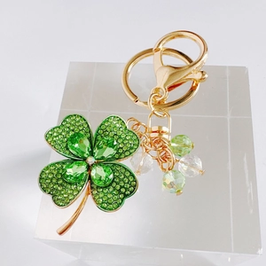 Detailed view of green rhinestone four-leaf clover keychain with crystal beads and gold ring