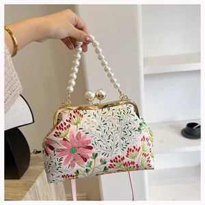 Details der Blumenstickerei und Perlengriff an der rosa Vintage-Abendhandtasche