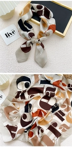 Detail of silk-like square scarf featuring vintage abstract letter print and smooth texture