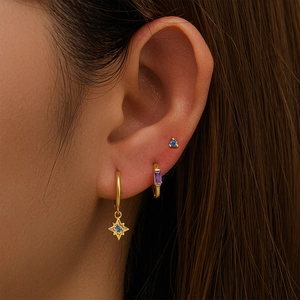 Detailed view of gold S925 silver hoop earrings with blue and purple zircon charms