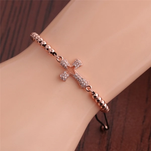 Detail of rose gold cross bracelet with cubic zirconia stones on adjustable bead chain