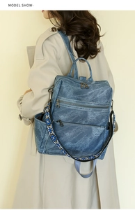 Detail of vintage blue denim backpack with ethnic style knit shoulder strap
