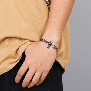Mens vintage stainless steel curb chain bracelet with a central cross charm on wrist
