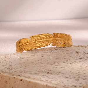 Detailed macro view of 18K gold-plated leaf bangle with realistic feather texture details