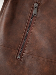 Vue macro détaillée de la fermeture éclair en métal sur une veste en cuir marron vintage