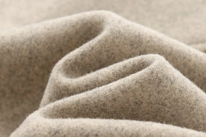 Détail macro du tissu en mélange de laine beige avec une texture tricotée douce
