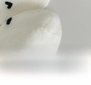 Detail of reinforced sock toe featuring black heart pattern and seamless knitting texture