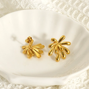 Golden irregular firework earrings with fluid metallic texture in a seashell dish