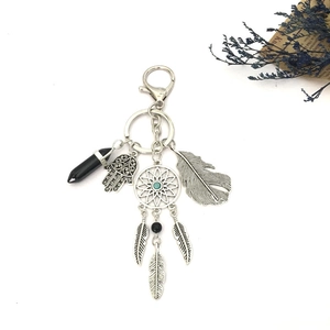 Bohemian silver keychain featuring hamsa hand, dreamcatcher, feather and black crystal