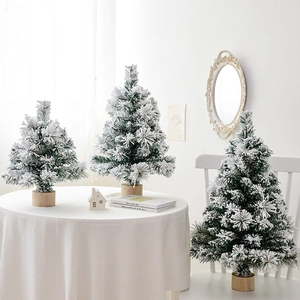 Mini flocked Christmas trees with natural wood bases in three sizes for winter home decor