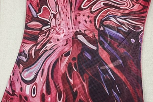 Detail of vintage abstract print fabric with breathable mesh texture in deep red and purple