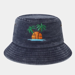 Detail of tropical palm tree embroidery and metal eyelet on blue denim bucket hat