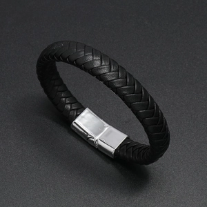 Detail of black braided leather bracelet with a polished metal magnetic clasp closure