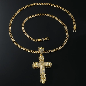 Sparkling gold plated cross pendant necklace with rhinestones on black reflective surface