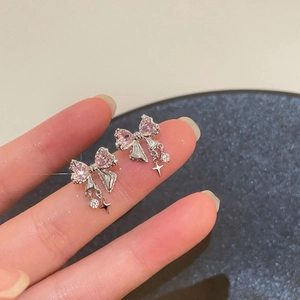 Makroaufnahme der silbernen Schleifenohrstecker mit rosa Herz-Zirkonia und Sternen