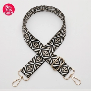 Detail of adjustable nylon strap with gold buckles and black white geometric patterns