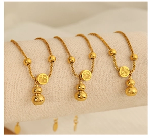 Macro detail of gold titanium steel bracelets with gourd pendants and Fu character charms